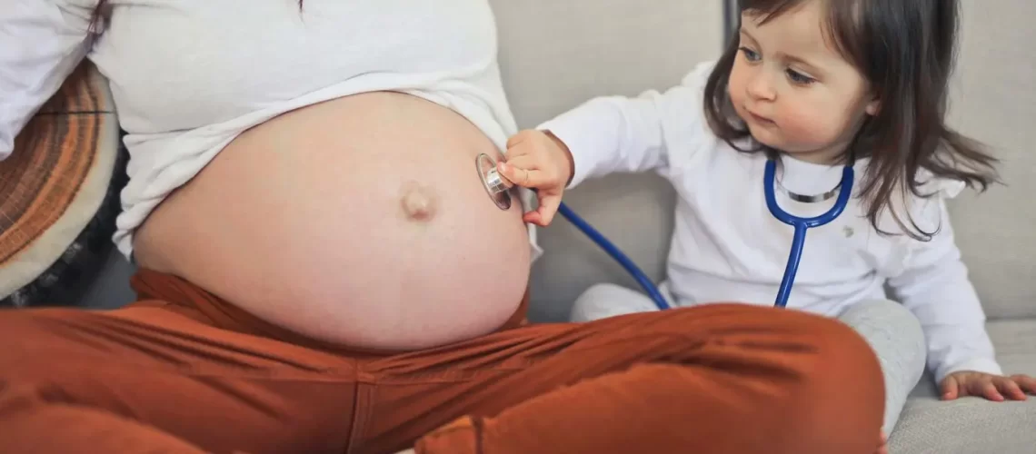 little-girl-listens-with-stethoscope-belly-pregnant-mom_641386-101